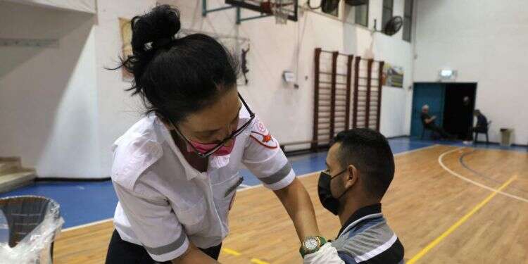 עמדת חיסונים לקורונה בחולון. צילום: AFP נתון מדאיג: מקדם ההדבקה עלה ל-1.11