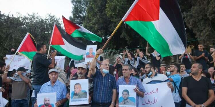 מפגינים מניפים דגלי אש ישראל לא יכולה להימלט מאבו-מאזן