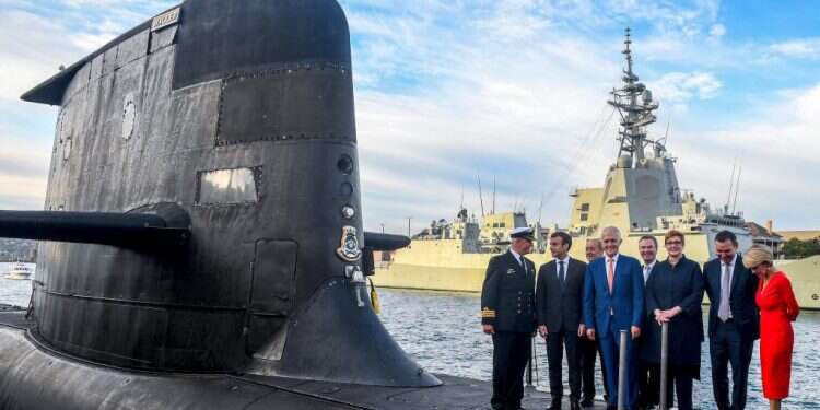 מקרון (שני משמאל) וראש ממשלת אוסטרליה דאז טרנבול (במרכז) בסידני, 2018. צילום: AFP משבר עסקת הצוללות: שגריר צרפת ישוב לוושינגטון