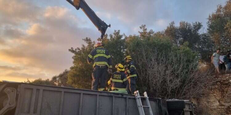 כוחות הכיבוי וההצלה מנסים להפוך את האוטובוס כדי לחלץ את הגבר הלכוד תחתיו. צילום: כיבוי אש חמישה הרוגים בהתנגשות רכב פרטי עם אוטובוס ליד חורפיש