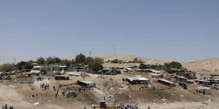 מפגינים פלסטינים מונעים מטרקטור לממש את
צווי ההריסה בחאן אל־אחמר, 4 ביולי 2018. צילום: אי.פי.איי