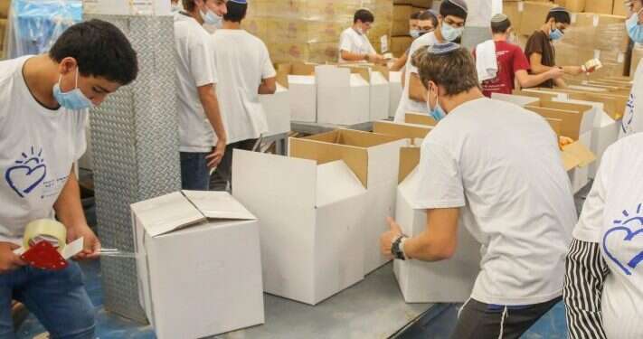 מתנדבים אורזים חבילות מזון לחלוקה מטעם עמותת חסדי נעמי (למצולמים אין קשר לכתבה). צילום: יהושע יוסף האשמים תמיד: הדה־לגיטימציה כלפיי הציונות הדתית חוצה גבולות