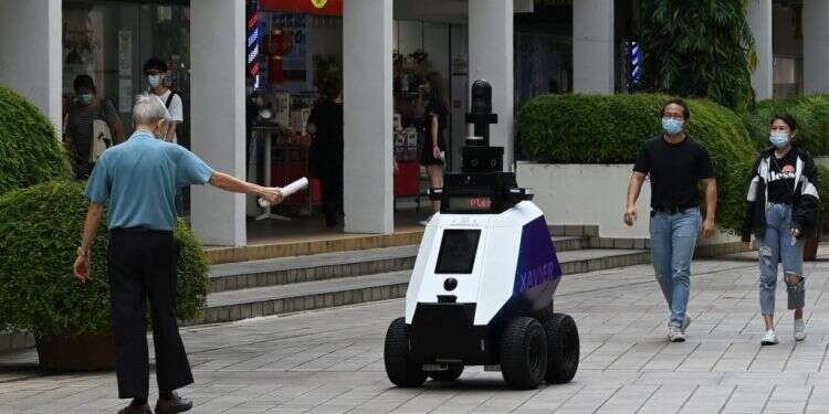 רובוט פיקוח בסינגפור. צילום: AFP סינגפור: רובוטים מסיירים ברחובות ומחלקים הוראות