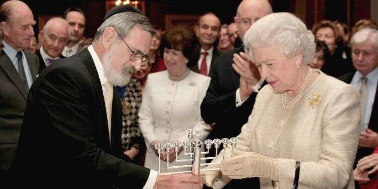 היהודים לא יוכלו להביא ברכה לעולם אם יתנתקו ממנו. הרב זקס מעניק חנוכייה למלכת בריטניה, 2006. צילום: AP צ'רצ'יל, טרומן ו-7 באוקטובר: אסור לוותר על קשרים אישיים לטובת מדינת ישראל
