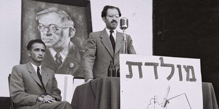 מנחם בגין באסיפת בחירות בתל אביב, 1948 .יושב לצידו, חיים לנדאו. צילום: הנס פין