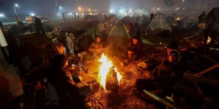 מהגרים על גבול בלארוס־פולין מציתים אש כדי להתחמם. צילום: איי.אף.פי בלארוס: לוקשנקו מנסה לרדת מהעץ