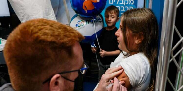 ילדים ישראלים מתחסנים נגד קורונה. צילום: AFP מומחים במערכת הבריאות: לחסן ילדים שחלו בקורונה והחלימו
