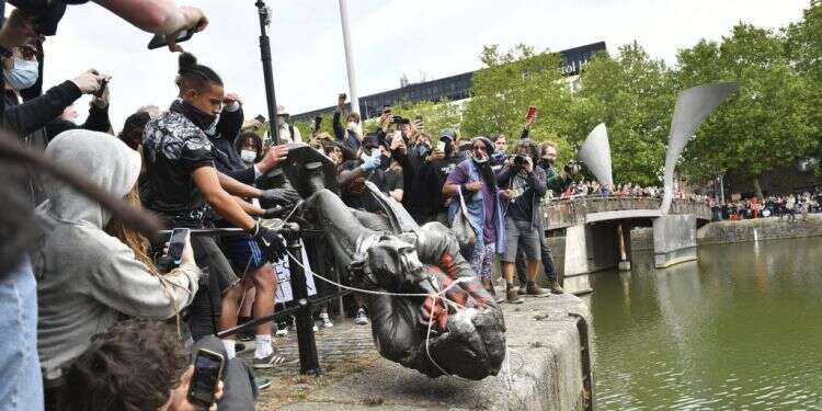 מנסים לשכנע שכל הדמוקרטיות המערביות גזעניות ביסודן. מפגינים זורקים לנהר פסל של סוחר העבדים אדוארד קולסטון בבריסטול, אנגליה, 2020. צילום: AP