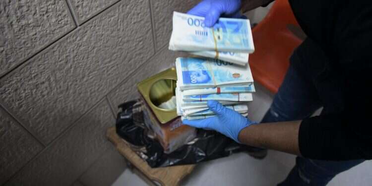 כסף שנתפס בפשיטת המשטרה בנצרת. צילום: דוברות המשטרה המלחמה בפשיעה במגזר הערבי: נעצרו 9 בחשד שאיימו לנקום ברצח