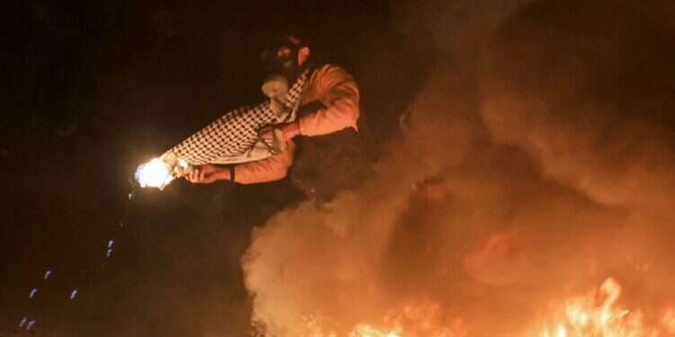 פלסטיני משליך בקבוק תבערה. צילום: AFP המתיחות גוברת: בקבוק תבערה הושלך לעבר עמדה צבאית