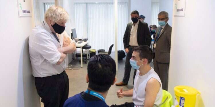 בוריס ג'ונסון עם מתחסנים צעירים, החודש. צילום: AFP הקורונה מזנקת בבריטניה וקרנו של בוריס ג'ונסון יורדת