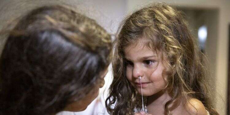 נערה בודקת את אחותה בבדיקת אנטיגן (אילוסטרציה). צילום: אוליבייה פיטוסי פלאש 90 הפוליטיקה שמאחורי הפרטת המגפה