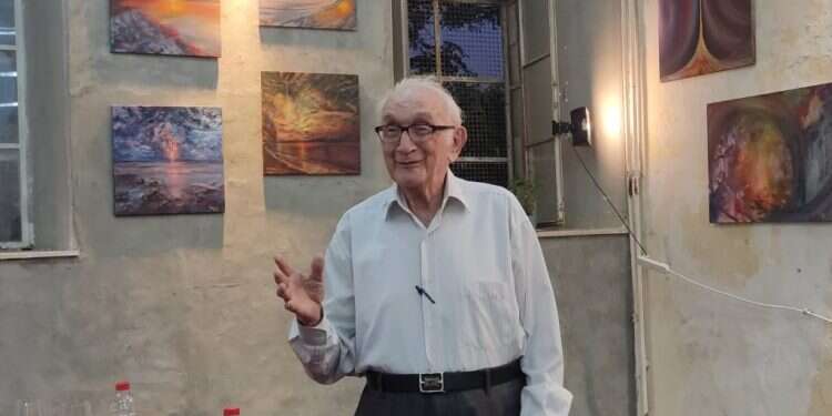 משה זקס בביתו, על רקע ציוריו. צילום: באדיבות המשפחה