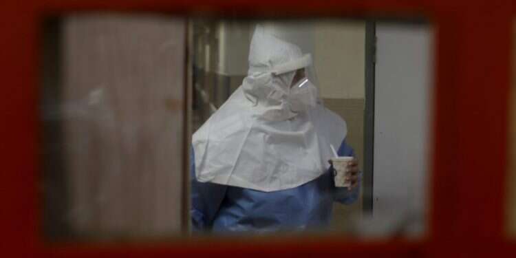 עובד במחלקת קורונה בבית החולים זיו בצפת. צילום: EPA מומחים חוששים: זן BA.2 עלול לבלום את הירידה בתחלואה