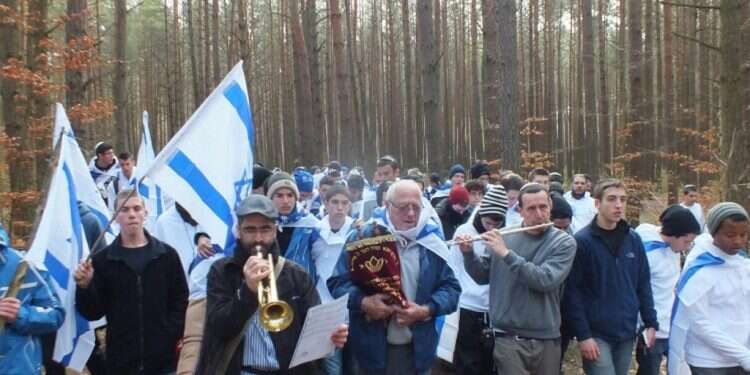 ניצול תאומי מנגלה מאוושויץ, צבי ויזל, אוחז בידו ספר תורה מימי השואה. "במסעות לפולין נפתחים שערי הלב"