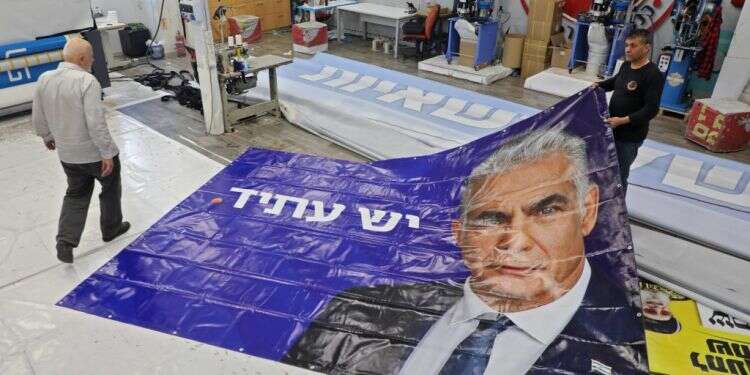 הדפסת שלט תעמולה של יאיר לפיד בבית דפוס בראש־העין, שלשום. צילום: AFP צילום: AFP