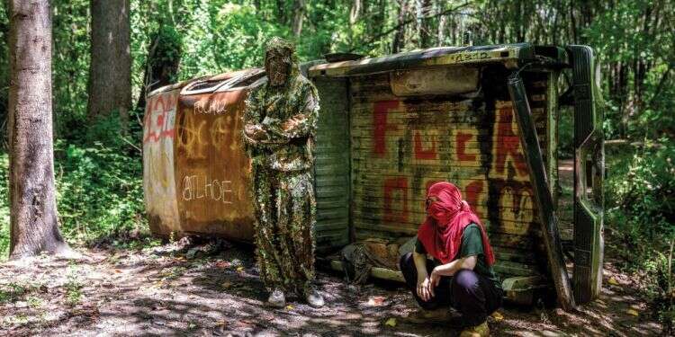 פעילים למען היער על רקע הטנדר השרוף. צילום: Jack Crosbie for Rolling Stone האנרכיסטים שהשתלטו על היער של אטלנטה ונשבעים להגן עליו בכל האמצעים