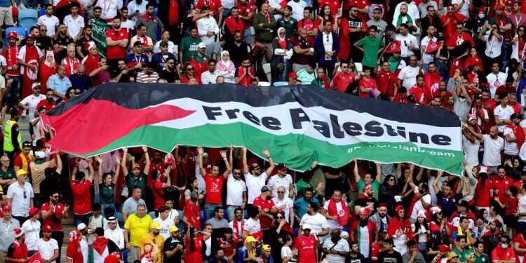 אוהדי תוניסיה במשחק אמש, עם שלט תמיכה בפלסטינים. צילום: EPA התקריות בקטאר: הכתבים הישראלים כאילו מבקשים שיפגעו בהם