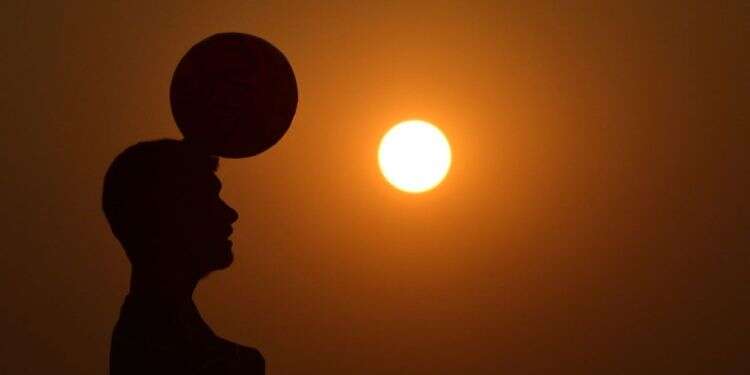 ילד משחק בכדור, קטאר 2022. קרדיט: AFP חומות שנבנו מסכסוך שגבה אלפי פצועים והרוגים, מתכופפות בפני המונדיאל