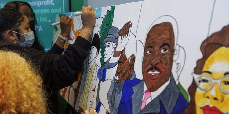 סטודנטים אמריקאיים עם תערוכת אומנות לזכר מרטין לות'ר קינג. צילום: EPA ארה"ב: שמונה בני אדם נורו במהלך חגיגות לציון יום מרטין לותר קינג