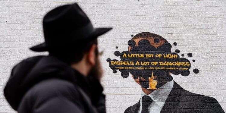 הרב אברהם קגן מביט על ציור הקיר המתוקן. צילום: ג'יימי קלטר דייויס, הוושינגטון פוסט מעשייה חסידית מודרנית: הרב משיקגו והציור המצונזר של קניה ווסט