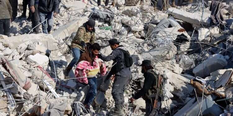 חילוץ גופה ברעידת האדמה בסוריה. צילום: AFP "שמענו שהם בחיים, שהם קראו מתחת להריסות": מעל 11 אלף הרוגים ברעידת האדמה