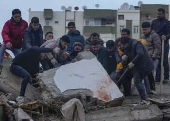 אנשים מחפשים ניצולים מתחת הריסות בניין בטורקיה. צילום: חליל חמרה, AP "שמענו שהם בחיים, שהם קראו מתחת להריסות": מעל 11 אלף הרוגים ברעידת האדמה