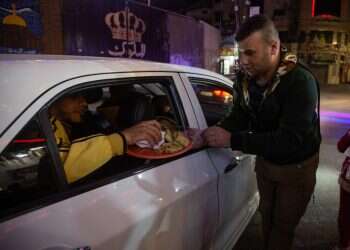 חלוקת ממתקים בחאן־יונס שברצועת עזה, לאחר הטבח בנווה־יעקב בליל השבת שעברה. צילום: גטי אימג'ס