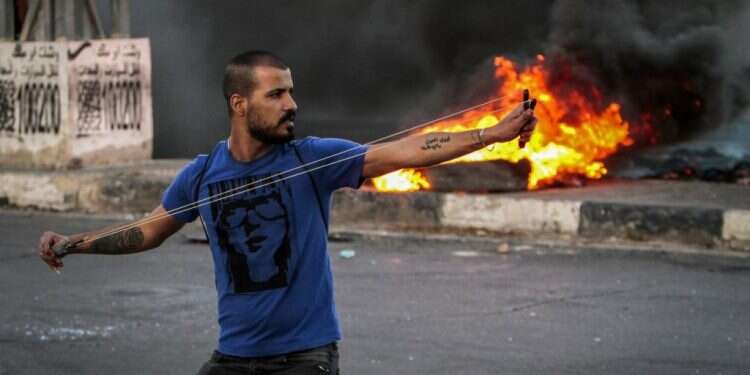 פלסטיני מתפרע בחווארה, 2021. צילום: נאסר אישתיה, פלאש 90