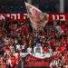 אוהדי הפועל ירושלים. צילום: אורן בן חקון/פלאש90 לא נעים לבוא למשחק של הפועל ירושלים בשחור לבן, אז התעטפנו באדום