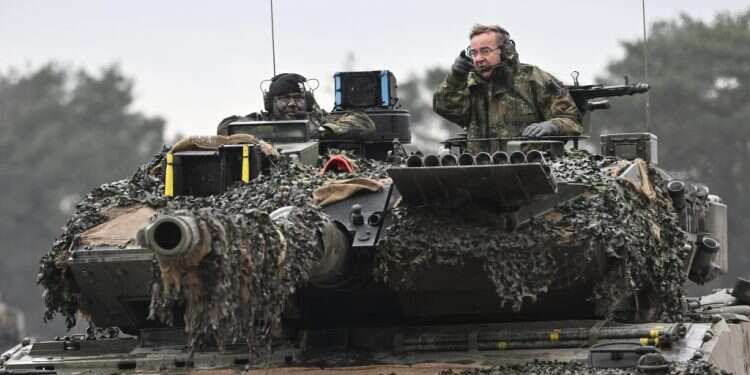 שר הביטחון של גרמניה ניצב בטנק לאופרד בתרגיל צבאי. צילום: גטי אימג'ס