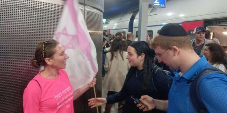 מפגינת ימין ושמאל מחליפות דגלים. צילום: שילה פריד הרגעים הקטנים והמרגשים: הפגנת תומכי הרפורמה הפכה למקום של שיח וחיבור עם המתנגדים