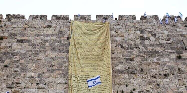 מפגינים תולים את מגילת העצמאות על חומות ירושלים. צילום: רויטרס שמרני ישראל: צאו נגד ההפיכה השלטונית. חזרו לעצמכם