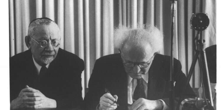 הרב מימון לצידו של דוד בן גוריון בחתימה על מגילת העצמאות. צילום: הנס פין, לע אפילו כשאנחנו נאבקים בתוך עצמנו, שני הצדדים גאים להניף את דגל ישראל