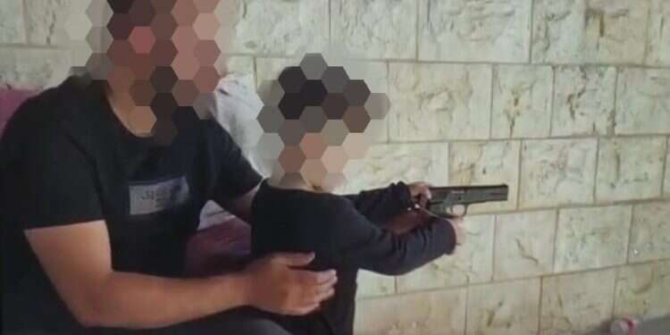 צילום מסך מתוך הסרטון של הדוד שנותן לאחייניו לירות בנשק הוארך מעצרו של תושב טייבה שתועד נותן לאחייניו הקטנים לירות בנשק