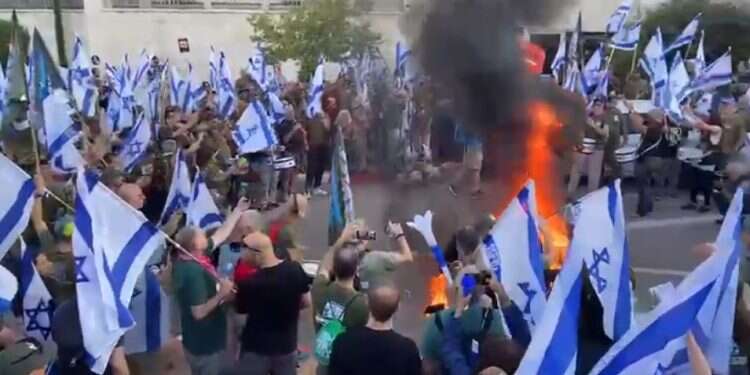 אחים לנשק מול ביתו של השר לוין. צילום מסך מתוך סרטון חסימת כבישים ומדורה: מפגיני השמאל בהתפרעות מכוערת מול ביתו של שר המשפטים