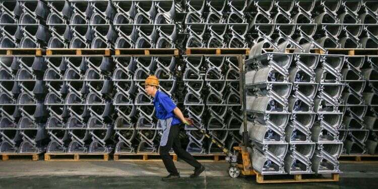 פועל סיני סוחב חלקי מעלית, מחוז ג'יאנגסו. צילום: AFP מסע בסין: הצצה לפער שבין החזית המרשימה לאמת שמאחוריה