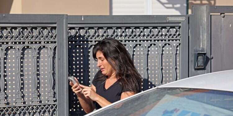 אישה מנסה להשיג את קרוביה. צילום: AFP