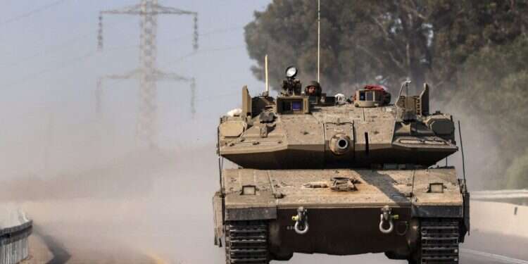 טנק נוסע על הכביש ליד העיר שדרות לכיוון גבול רצועת עזה. צילום: AFP