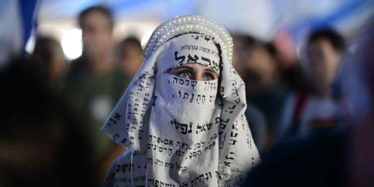 מפגינה נגד הרפורמה המשפטית. צילום: תומר נויברג - פלאש 90 רון חולדאי עם ספר תורה: הפתרון למצב הקשה בת"א לא נמצא בידי הדתיים