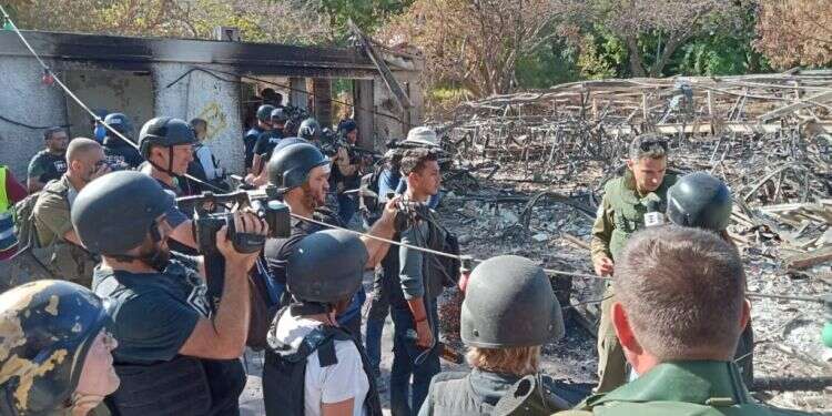 עיתונאים זרים מסיירים בין הריסות קיבוץ בארי. צילום: לב ארן