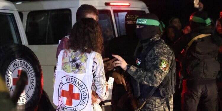 החטופים מועברים לצלב האדום על ידי אנשי חמאס בעזקה לפני כשנה. צילום: AFP המנהרות קיימות, השטח לא נכבש: ישראל רחוקה מאוד מהשמדת חמאס