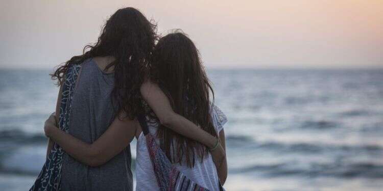 נערות מתחבקות מול שקיעה בחוף הים בתל אביב. צילום: הדס פרוש, פלאש90 מאז השביעי באוקטובר החיים של טכנאי הדודים שלי השתנו