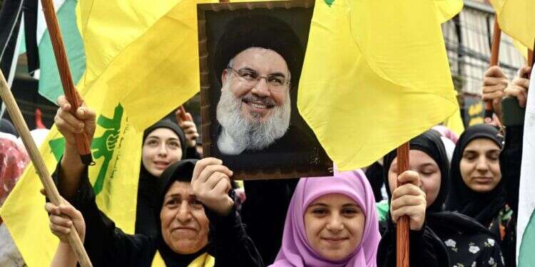 תומכי חיזבאללה מניפים את דיוקנו של חסן נסראללה. צילום: EPA תומכי חיזבאללה מניפים את דיוקנו של חסן נסראללה