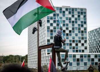 מפגין פרו-פלסטיני מניף דגל אש"ף מול בית הדין הפלילי הבינלאומי בהאג