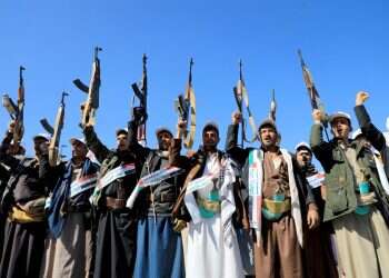 לוחמים חות'ים מניפים את נשקיהם בהפגנה בתימן