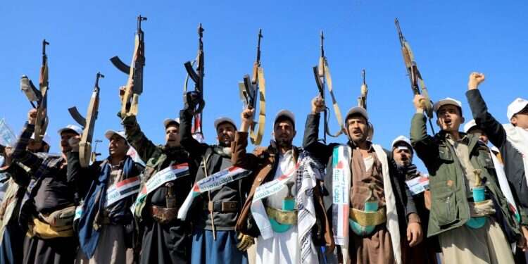 לוחמים חות'ים מניפים את נשקיהם בהפגנה בתימן