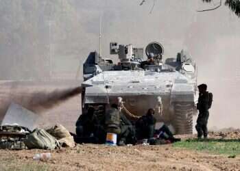 כוחות ישראלים מחוץ לרצועת עזה. צילום: AFP נגמ"ש וכוחות ישראלים מחוץ לרצועת עזה