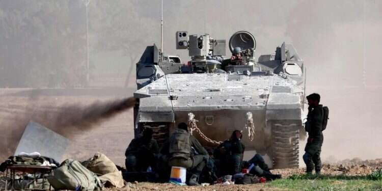 כוחות ישראלים מחוץ לרצועת עזה. צילום: AFP נגמ"ש וכוחות ישראלים מחוץ לרצועת עזה