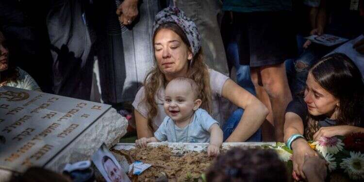 ענת מאיר, אלמנתו של דוד מאיר שנפל בשביעי באוקטובר, יחד עם בנם התינוק מתאבלת על קברו. צילום: חיים גולדברג - פלאש 90 ענת מאיר, אלמנתו של דוד מאיר שנפל בשביעי באוקטובר, יחד עם בנם התינוק מתאבלת על קברו